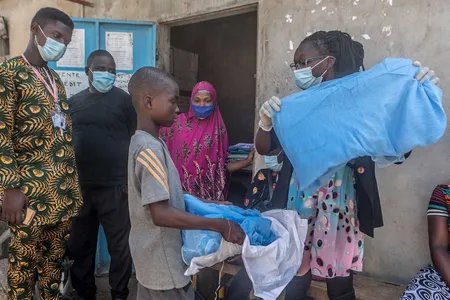 A young boy in Benin, in West Africa, receives a bed net designed to help prevent malaria. 
