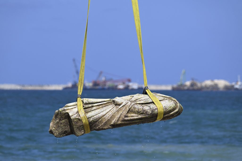 Ancient sculpture lifted by crane