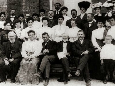 Industrialist Andrew Carnegie (front row, center) financially supported the Tuskegee Institute and its faculty members, pictured here. Carnegie lauded the efforts of Booker T. Washington, who opened the school in 1881, shown here with his wife Margaret next to the businessman.
