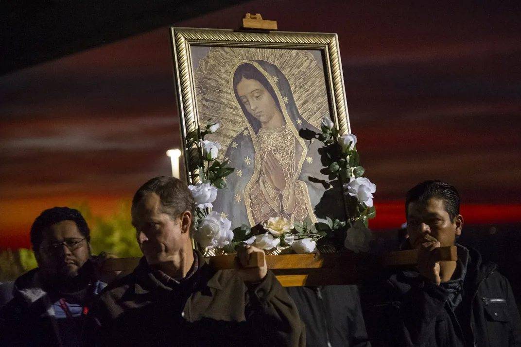 a portrait of the Virgin Mary is held in a procession