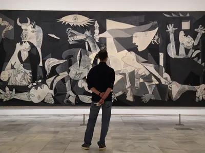 A visitor examines Pablo Picasso&#39;s Guernica during the partial reopening of the Reina Sof&iacute;a Museum in June 2020, which followed several months of pandemic closures.