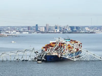 The steel frame of the Francis Scott Key Bridge rests atop of a container ship following the bridge&#39;s collapse on March 26, 2024.