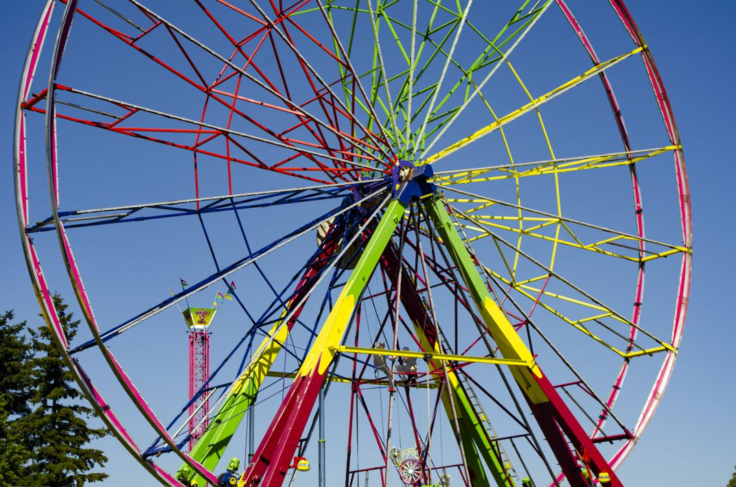 Travelling carnival fair amusements crew assembling a Ferris Wheel ...