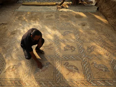 Palestinian farmer Salman al-Nabahin cleans the&nbsp;mosaic&nbsp;he uncovered in Gaza.