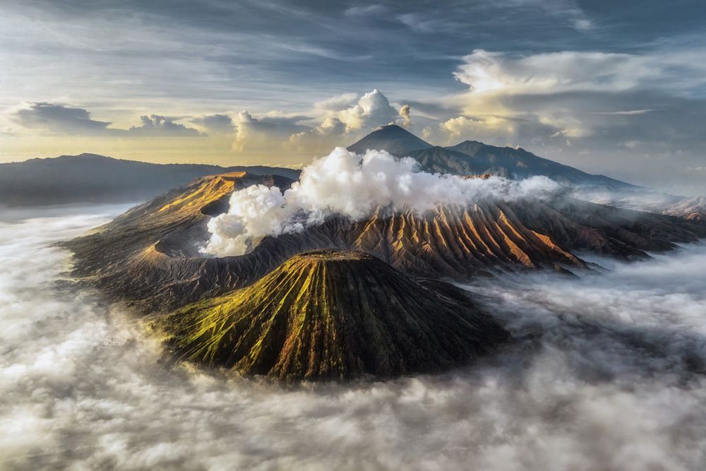 As the sun rises over Mount Bromo, mist drifts slowly through the rugged valleys and volcanic ridges. The first light touches the rough slopes, revealing a landscape that feels ancient and alive. In the quiet of the moment, the raw beauty of the mountain creates a deep sense of awe and respect for the powerful forces that shaped it.