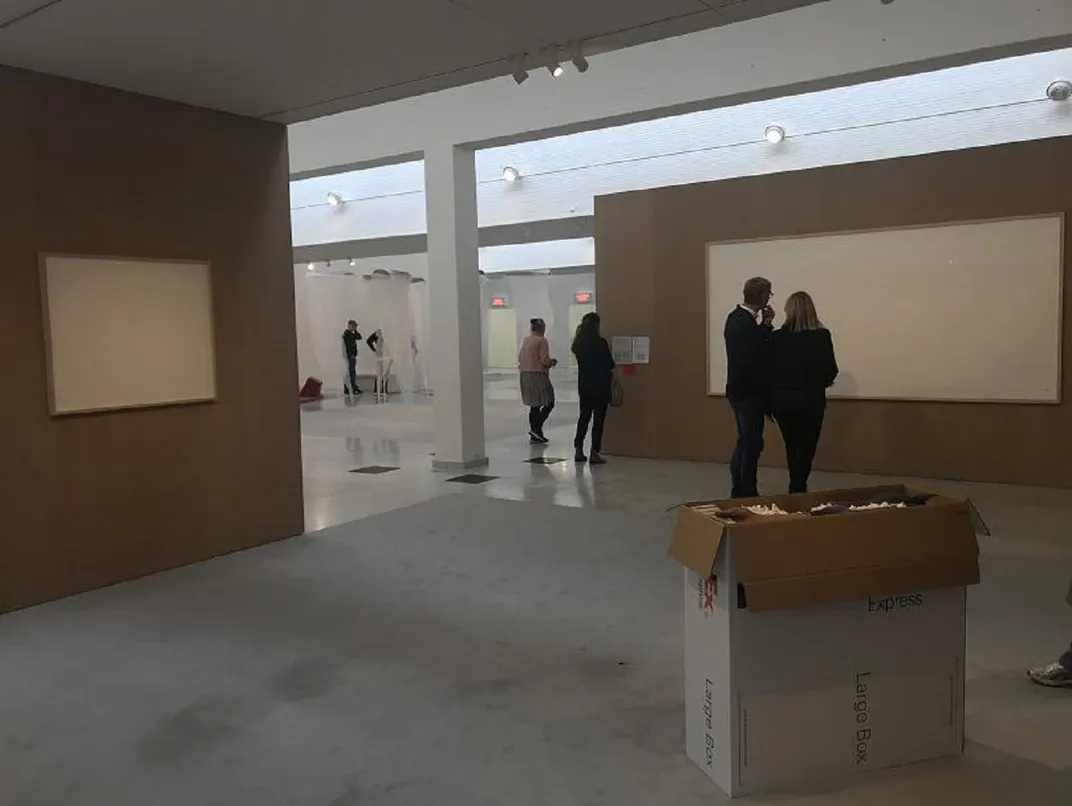 People look at the blank canvasses on display