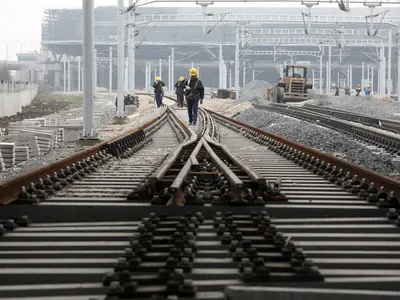 Workers lay railway tracks near the new railway station in Shanghai, China on 01 March 2010.