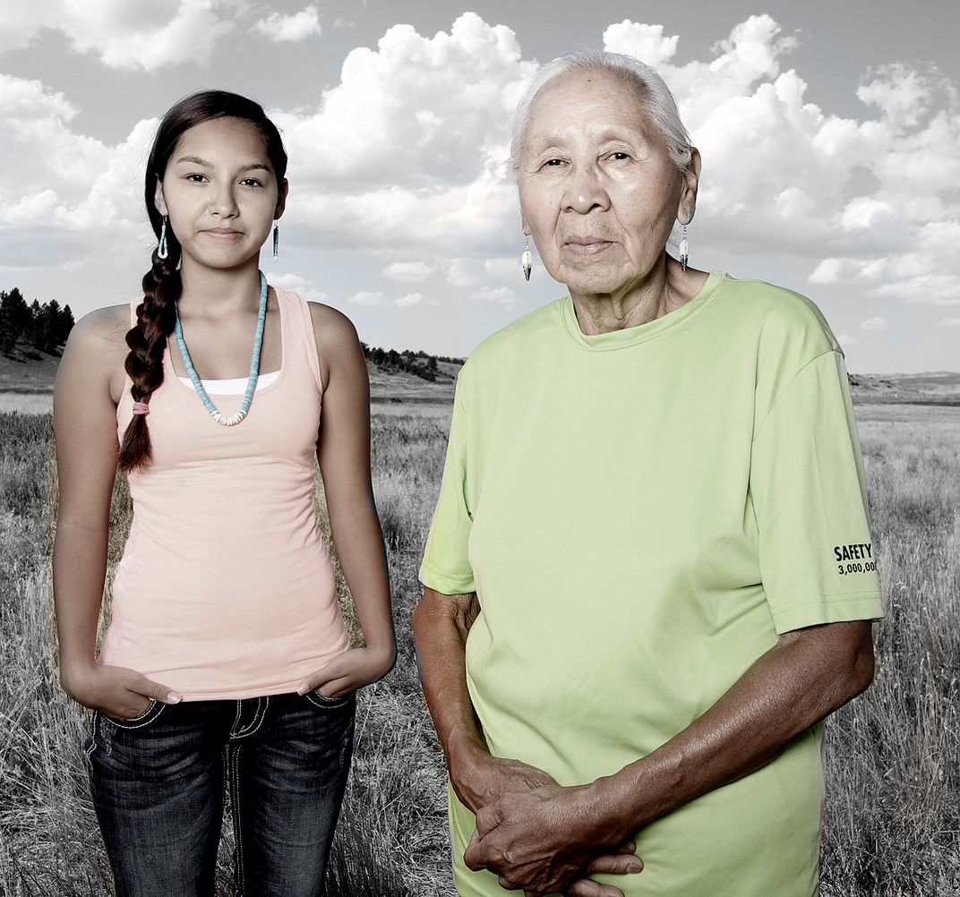 Two women stand in a field. 