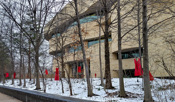 Red dresses displayed along the river walk of the National Museum of the American Indian in Washington, D.C., represent the crisis of missing or murdered Indigenous women and girls. Conceived by Canadian artist Jaime Black (Métis), 