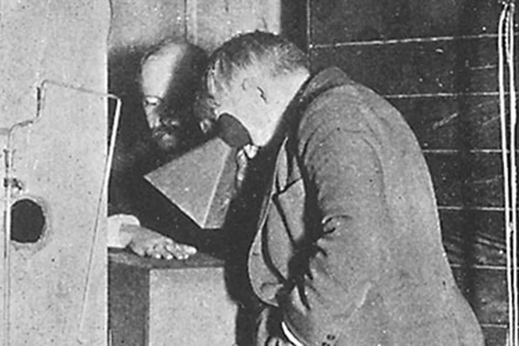 Thomas Edison examines Clarence Dally's, his assistant, hand thru a fluoroscope of his own design.