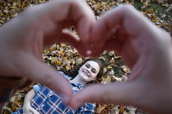 Heart-shaped hands create frame for loved one. thumbnail