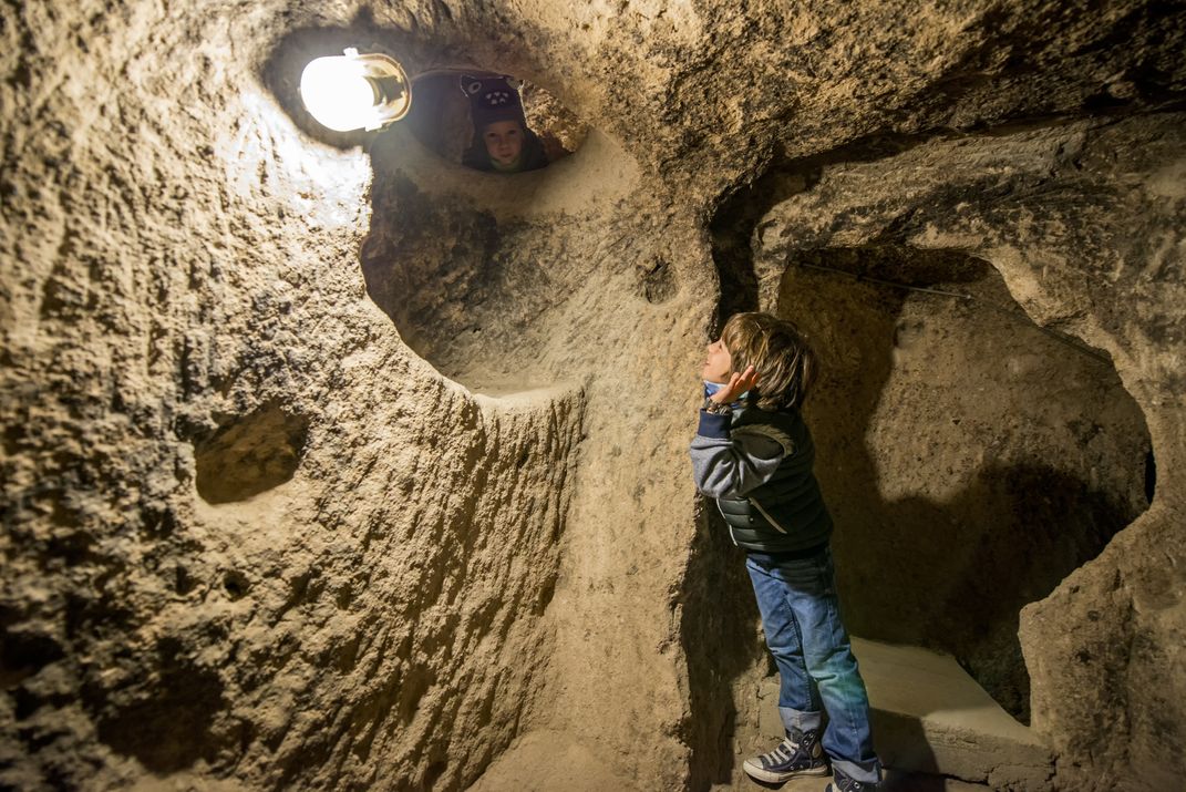 Little kids play inside the underground city of Derinkuyu in Turkey