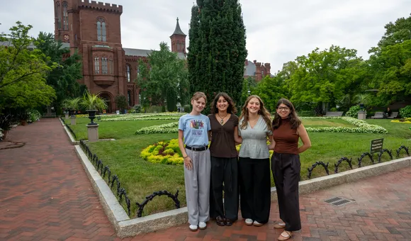 Four interns stand for a picture in front of the Smithsonian Castle’s garden entrance.
