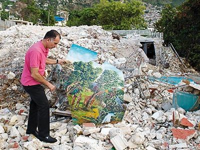 "We had 12,000 to 15,000 paintings here," says Georges Nader Jr., with a Paul Tanis work at the remains of his family's house and museum near Port-au-Prince.