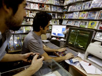 Iranian men play a soccer video game at a CD shop in Tehran June 10, 2006.