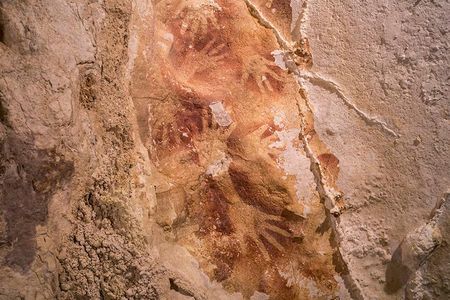 A hand stencil design on the wall of a cave in Sulawesi, Indonesia. 