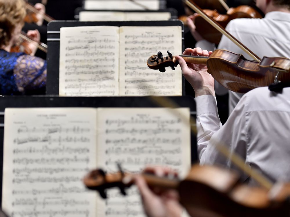 A row of musicians in front of sheet music