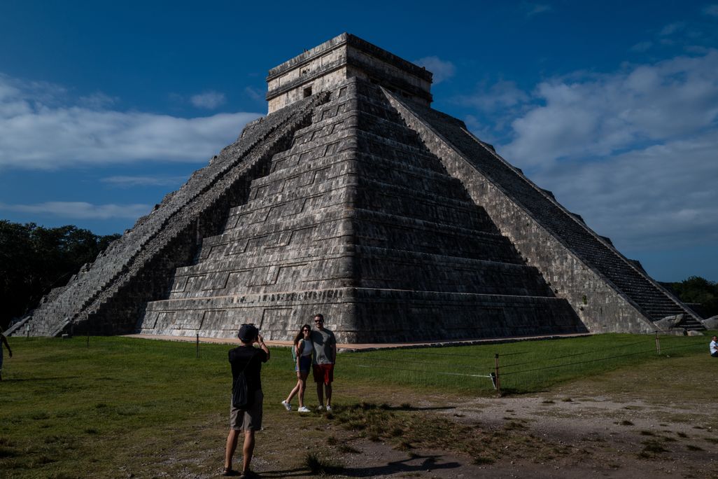Man and woman posing for photo in front of pyramid-like structure