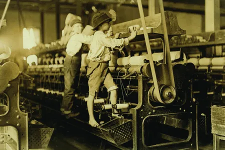 Two young boys at a Georgia cotton mill. Their slim arms and tiny hands were considered ideal for machine work.