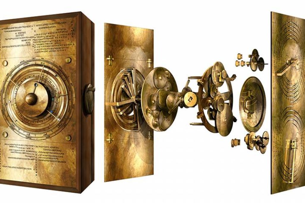 A model of a gleaming golden box, made of bronze, with detailed inscriptions, jeweled markers for planets and a clock-like face with complicated gear mechanisms behind