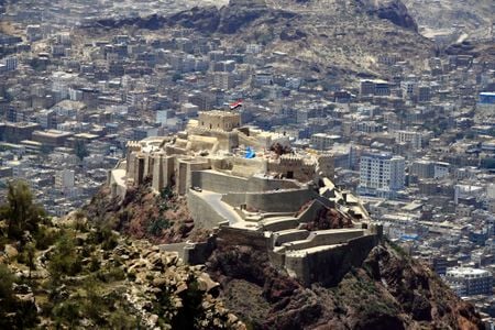 A giant Yemeni flag waves at the historic 12th-century citadel of al-Qahira in Taiz, in 2021, ahead of celebrations of the Muslim holiday of Eid al-Adha.&nbsp;