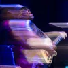 A man on a stage plays a guitar.