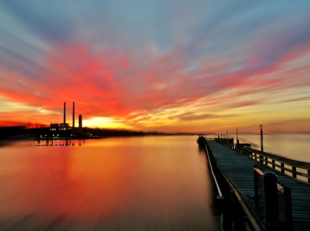 Vanishing sunset. July sunset in Port Jefferson, New York Harbor. Vivid colorful sunsets are a common occurrence at the harbor which is situated in a north by northwest direction. Although the sunsets are incredible they are far too short in duration.