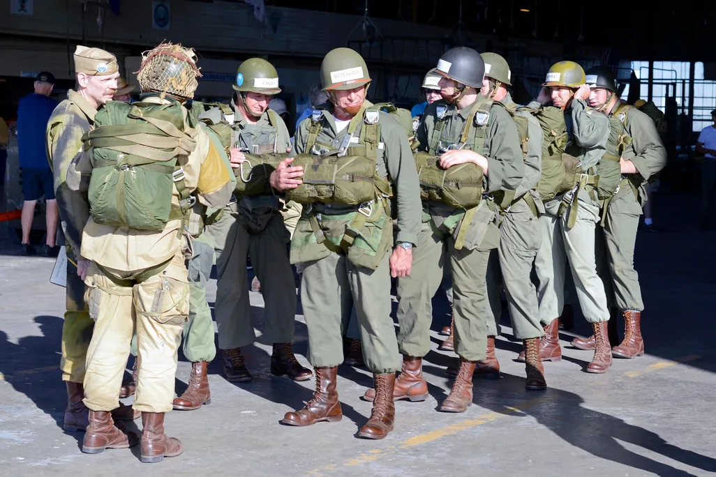 Men in green WWII-remniscent uniforms gather