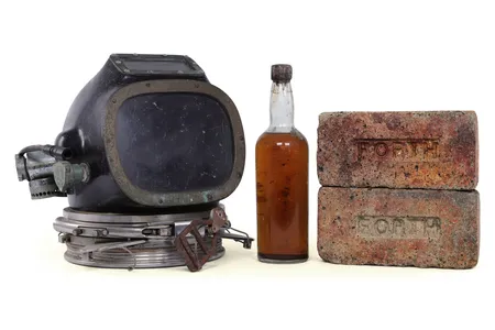 A bottle of whiskey, a diving helmet and bricks recovered from the wreck of the SS Politician, which sank off the coast of Scotland in 1941.