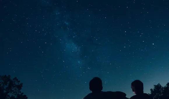 A pair of silhouetted people stargaze