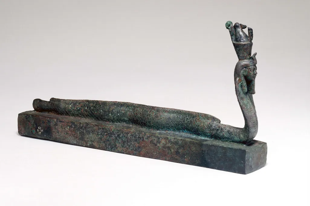 Small metal box topped with a figurine