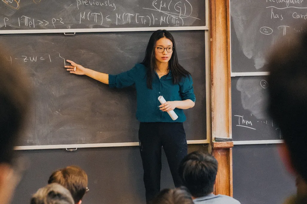 A woman writing on a blackboard