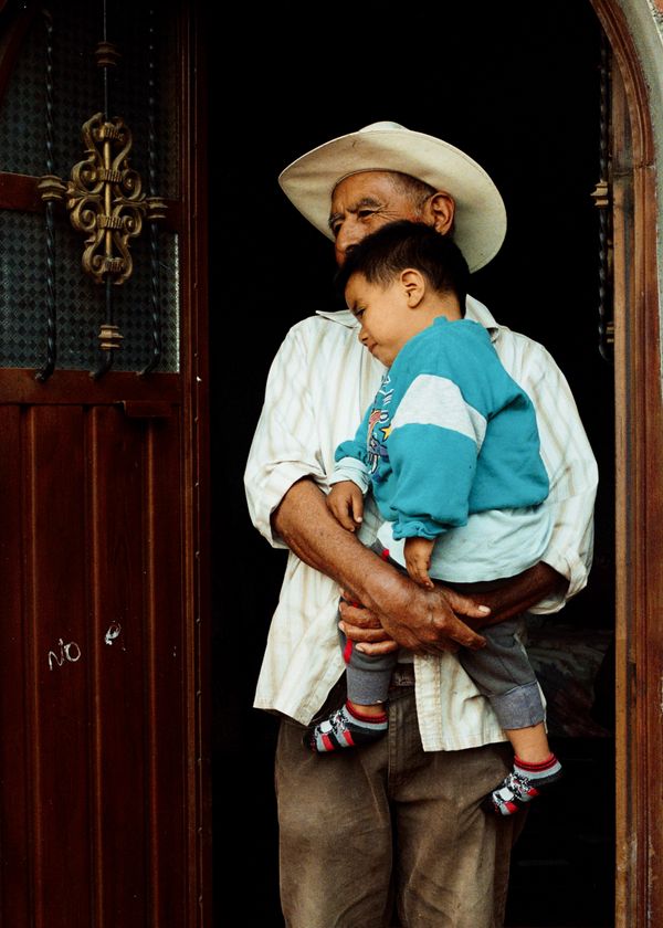 Oaxacan man from Teotitlan Del Valle carrying his grandson thumbnail