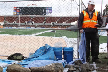 OSU archaeologist Loren Davis alongside the bones uncovered underneath the end zone.