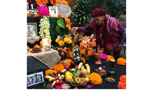 Doña Ofelia Esparza decorates the ofrenda 