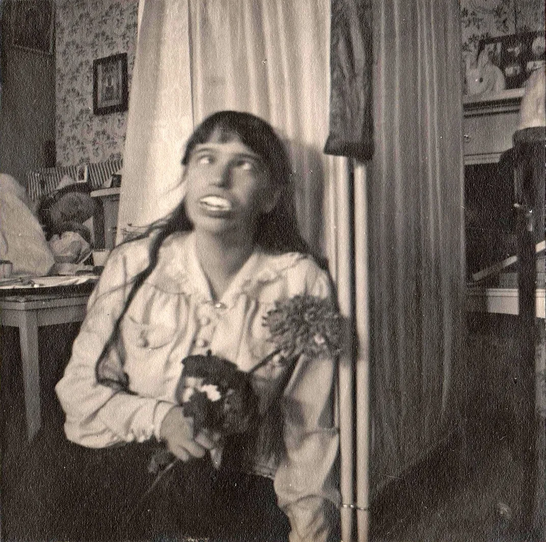 Anastasia wearing a set of false teeth. Her sister Olga is sleeping in the background.
