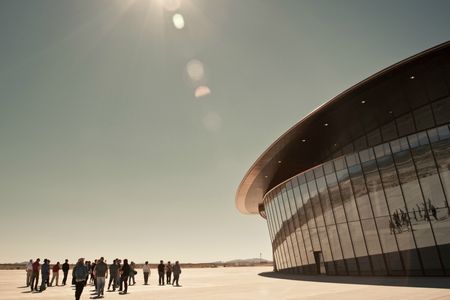 As spaceport passengers file into the main terminal for their flight, hidden doors hiss open to welcome them.