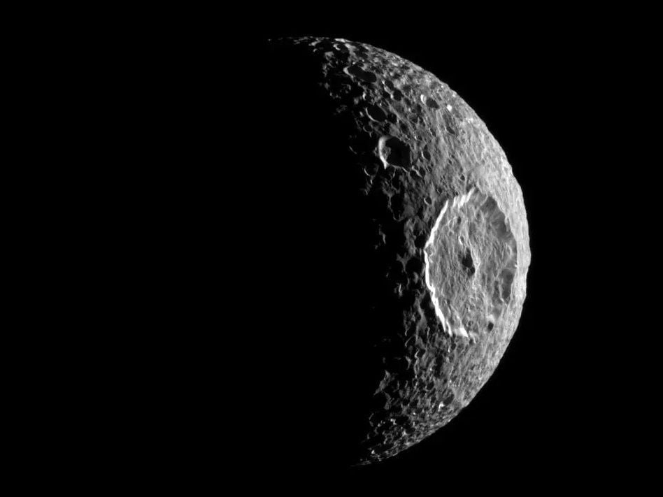 cratered moon in black and white with a large crater on its right side