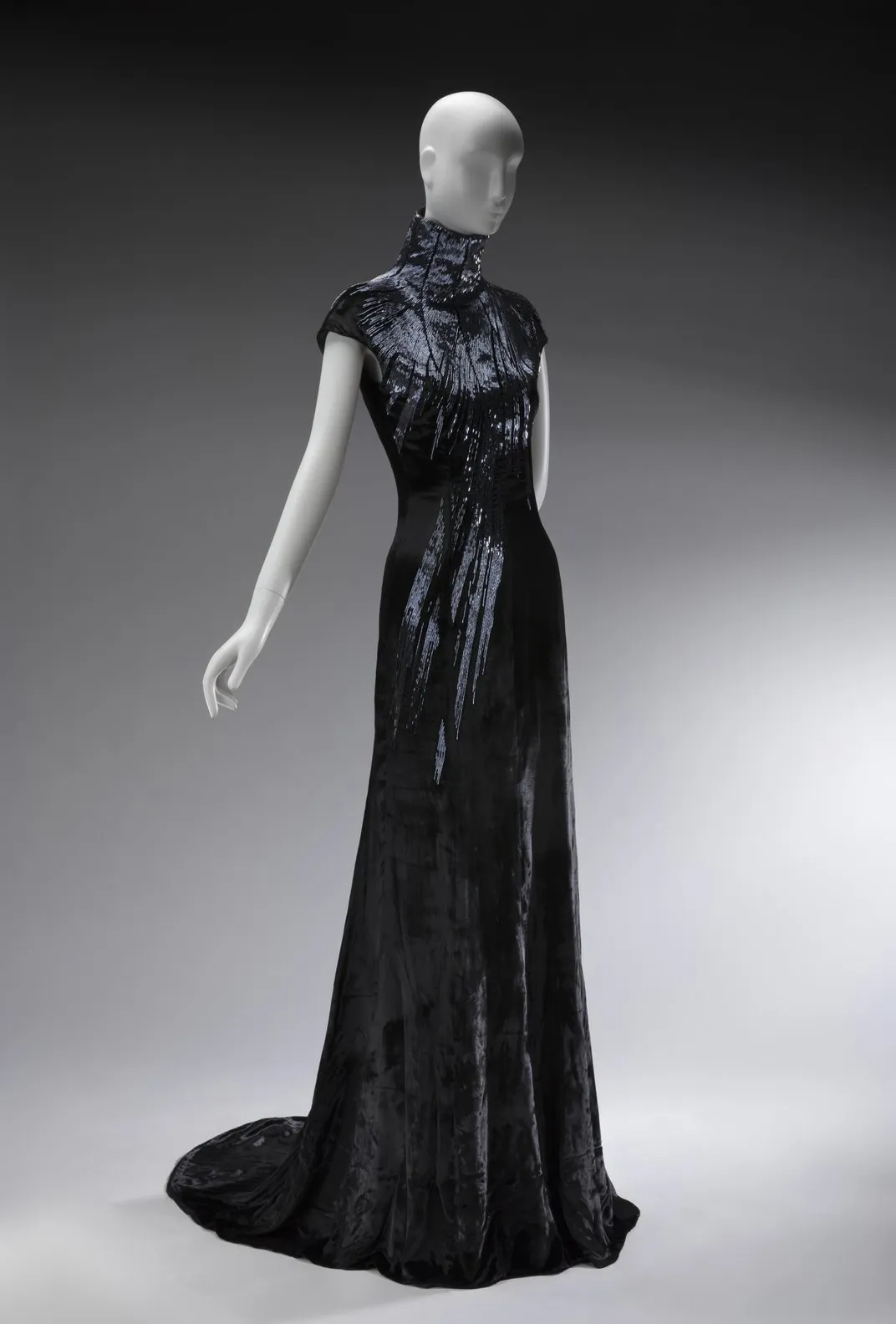 A form fitting velvet black dress with sequins running down from the neckline