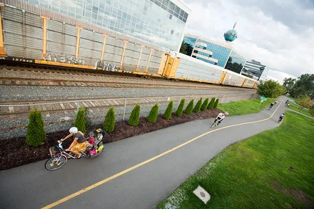 A family commutes by cargo bike on a rail-and-trail path in Seattle.
