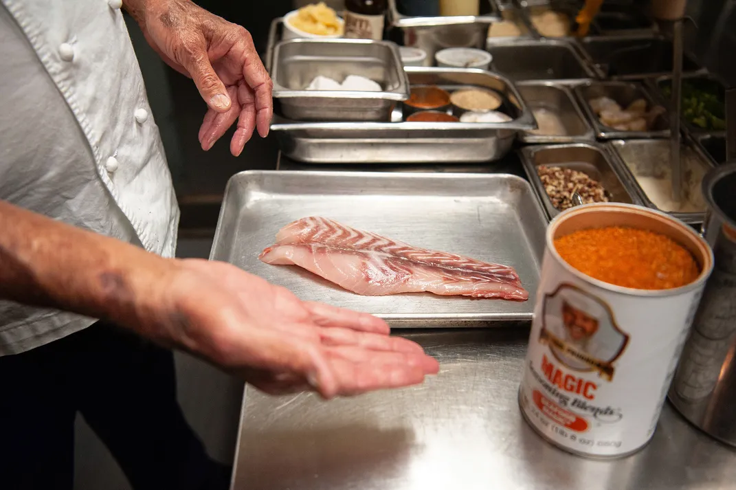 Master New Orleans chef Frank Brigtsen prepares to blacken a redfish fillet at his restaurant in New Orleans.