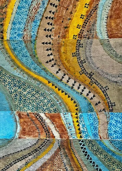 Painted bark cloth artwork resembling an overhead view of a river, with curving stripes of blue, yellow, and brown.