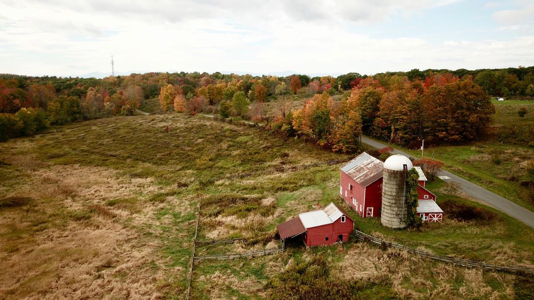 A vibrant red barn and autumn trees
