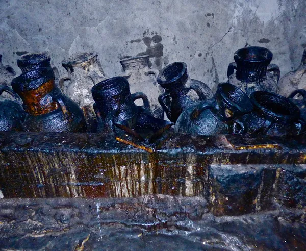 Huge dark oil jugs and wall markings in the darkness of Lalish Temple, the shrine of the Yezidis thumbnail