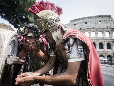 Centurions drink from a fountain near Rome's Coliseum during a heat wave in summer 2014. A recent announcement that centurion reenactors will be banned from the Coliseum during 2016 has led to protests and public outcry.