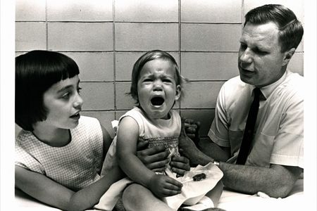 Hilleman's one-year-old daughter Kirsten (center, with her sister Jeryl Lynn and Dr. Robert Weibel) became the first to receive the mumps vaccine.