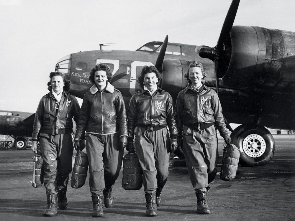 Women Airforce Service Pilots (left to right) Frances Green, Margaret Kirchner, Ann Waldner, and Blanche Osborn pass a line of Boeing B-17s