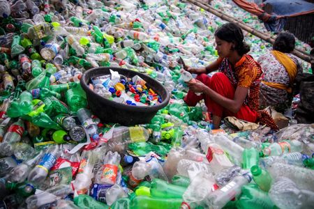 A worker sorts plastic in a recycling plant in Bangladesh. A new bacteria could make her job obsolete