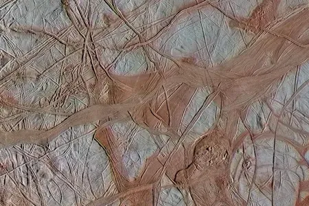 Underneath the cracked ice of Jupiter's moon Europa, there is likely a global ocean. Bluish ice in this Galileo spacecraft image is more pure water ice, while the reddish areas are ice mixed with other substances.