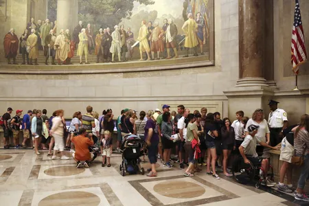 Visitors wait in line at the National Archives to view the Declaration of Independence (against the wall, center right), preserved under glass and special lighting, ahead of the Fourth of July Independence Day holiday in Washington, July 3, 2013.
